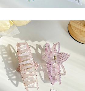 Vue détaillée des pinces à cheveux en acétate avec strass brillants en rose et violet