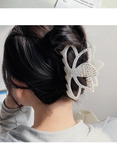 Détail d'une pince à cheveux en forme de lotus avec strass colorés sur de l'acétate