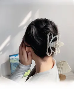 Détail d'une élégante pince à cheveux lotus avec strass colorés sur les cheveux d'une femme