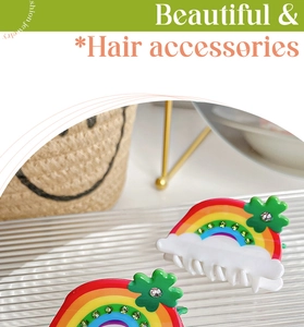 Close-up of rainbow hair clips with clover and rhinestone detail on a glass tray