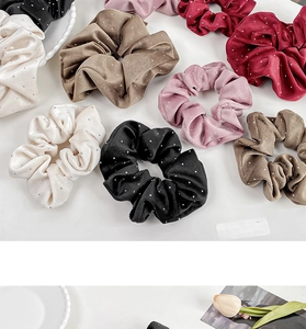 Close-up of velvet scrunchies with silver rhinestones in diverse colors and soft texture