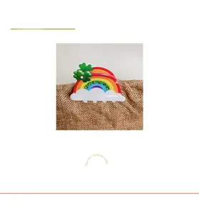 Rainbow hair claw clip with green clover and sparkling rhinestones on a burlap base