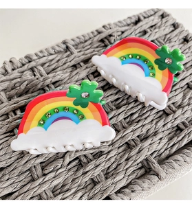 Detail of two rainbow cloud hair claws with rhinestones and four-leaf clover accents