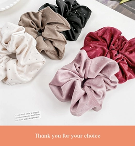 Close-up of velvet scrunchies with rhinestones in cream, brown, black, red, and pink
