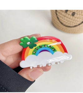 Detail view of rainbow hair claw clip with colorful acrylic finish and green clover