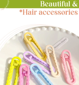 Détail de barrettes à cheveux ondulées aux couleurs pastel dans un plat en céramique