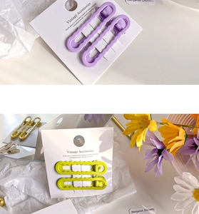 Gros plan sur des barrettes ondulées violettes et jaunes avec charnière en métal