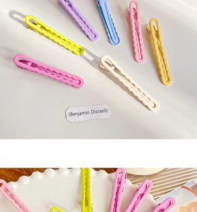 Close-up of wavy candy-colored metal hair clips in macaron shades of pink and yellow