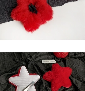 Detail of red plush star hair clips featuring metal duckbill clips and soft fuzzy texture