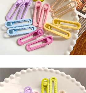 Détail de pinces à cheveux ondulées aux couleurs de bonbons sur une assiette en céramique