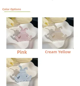 Close-up of cute rabbit hair claws in pink, yellow and blue with pearl decorations