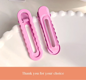 Détail de barrettes à cheveux roses en métal sur une assiette avec carte de merci
