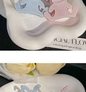 Detail showing acetate hair claw with fine glitter finish and elegant pearl embellishments