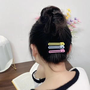 Set of 3 candy-colored wavy hairpins in yellow, light blue, and pink on a dark hair bun