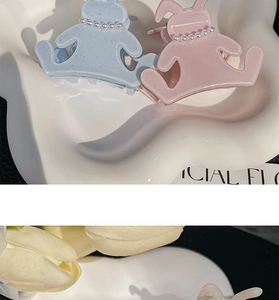 Detail of sweet acetate bunny hair claws in pink and blue colors with faux pearl collars
