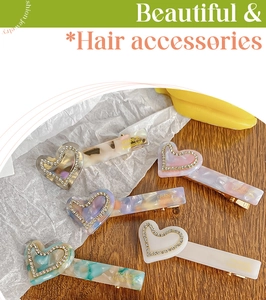 Close-up of acetic acid heart hair clips with marble texture and sparkling rhinestones