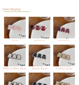 Detail view of colorful acrylic cat and bear hair clips with gold French metal hardware