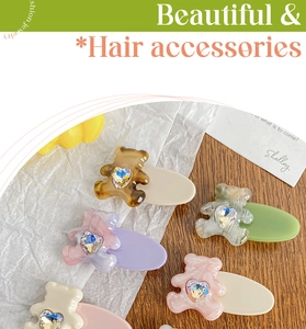 Dettaglio di simpatiche mollette per capelli a forma di orso con strass a cuore scintillanti