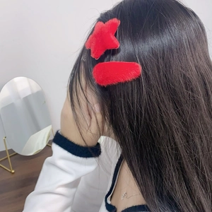 Plush red hair clips set featuring star and oval shapes worn by a model in a cozy indoor setting