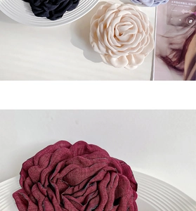 Detailed view of handmade fabric rose hair clips in beige, burgundy, and black finishes
