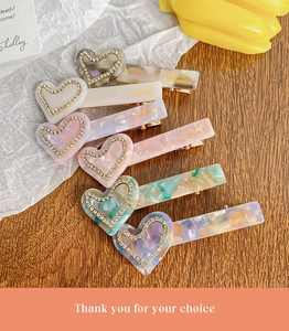 Detail of six acetate heart hair clips with rhinestones and France Handmade gold lettering