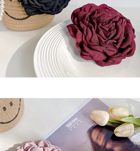 Detailed view of layered handmade fabric rose hair clips in burgundy, pink and black
