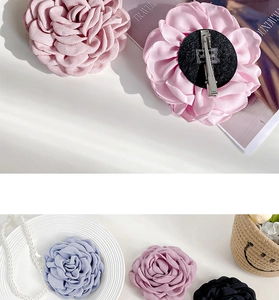 Detail of layered fabric rose hair clip with metal duckbill clip and brooch pin back