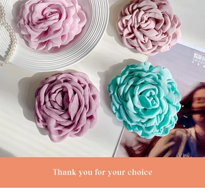 Flat lay of handmade fabric rose hair clips in pink and blue with pearl accessories