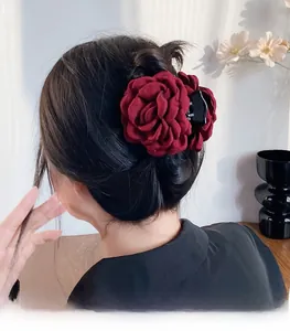 Gros plan d'une pince à cheveux rose en tissu bordeaux faite main sur modèle