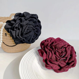 Handmade 3D fabric rose hair clips in black and wine red colors on aesthetic props