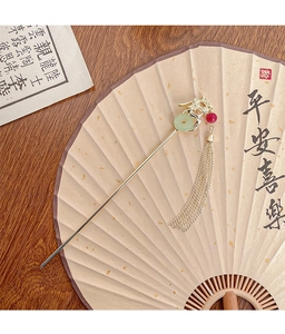 Close-up of golden dragon hairpin with green jade ring and long elegant tassels