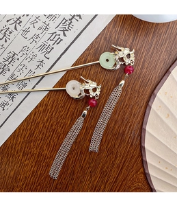 Detailed close-up of golden dragon hairpins with jade-like rings and elegant long tassels