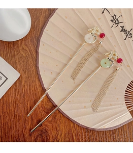 Detail of traditional Chinese dragon hairpins with jade rings and long golden tassels