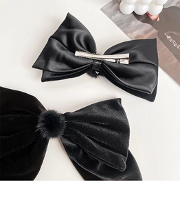 Close-up of black velvet and satin bow clips featuring durable silver metal alligator grips