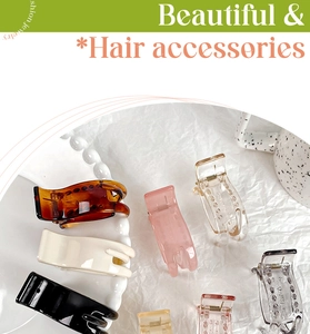 Close-up of assorted claw hair clips in various colors on a stylish textured display