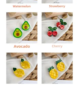 Close-up of mini acetate hair claws in cute fruit designs like avocado and cherry
