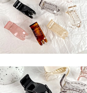 Detailed close-up of colorful matte and transparent hair claw clips in various neutral tones