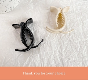 Set of minimalist glossy hair claw clips in black and cream beige on white paper