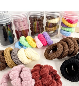 Dettaglio di elastici per capelli multicolori senza cuciture in un barattolo trasparente