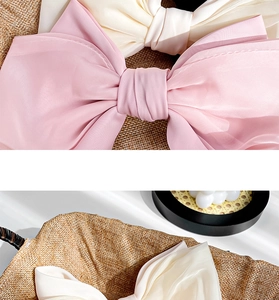 Detail of large satin bow hair clip fabric texture and elegant craftsmanship in pink