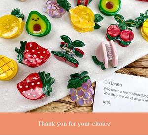 Mini fruit cellulose acetate hair claws showing strawberry, lemon, and peach designs
