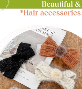 Detailed view of knitted bow hair clips with soft pom-poms in black, caramel and beige