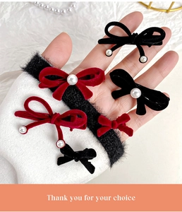 Close-up of vintage red velvet bow hair clips with pearls and elegant long ribbons