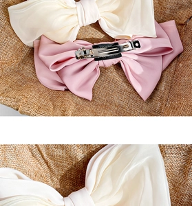 Detailed close-up of soft satin bow hair clips with durable metal spring fasteners
