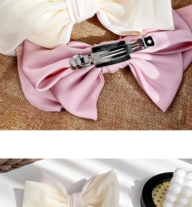 Detail view of the metal duckbill clip and non-slip lining on satin bow hair clip