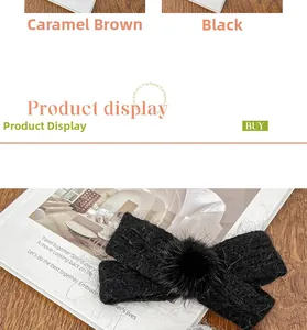 Detail of black knitted bow hair clip with faux fur pompom and soft wool texture