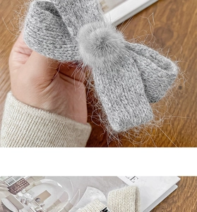 Detailed close-up of knitted bow hair clips with soft fur balls and textured yarn