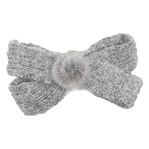 Elegant grey knitted bow hair clip with soft pom-pom detail for a cozy winter style