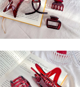 Detailed view of various burgundy hair claws on a French magazine background