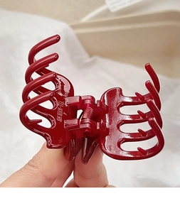 Detail of deep red large hair claw clip with glossy finish and durable metal spring
